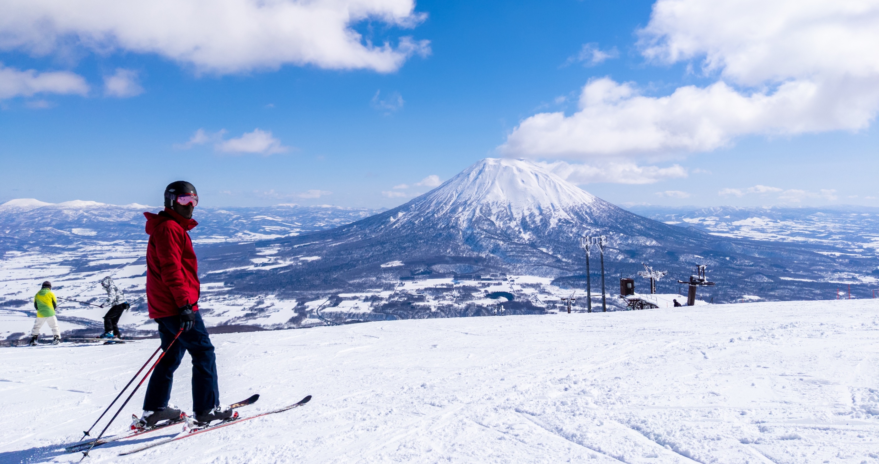 daredevil skiers ski on slope next to active volcano